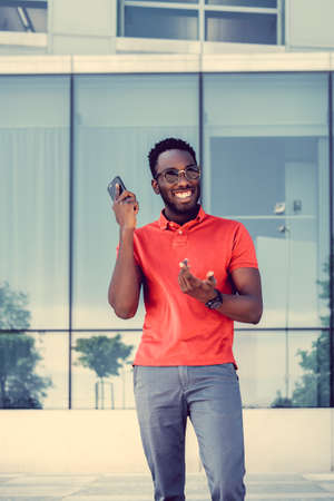 Portrait of casual black male with smartphone in a red t shirt.