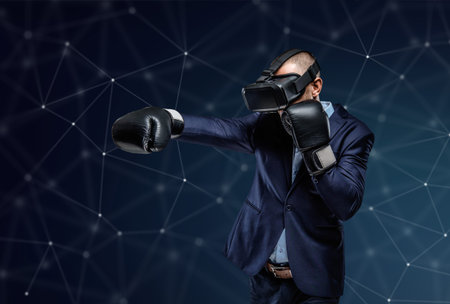 Fighter in a suit with virtual reality glasses device on his head over futuristic background.