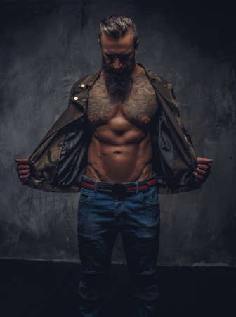 Portrait of modern bearded male in denim jeans and casual jacket dressed on naked torso.