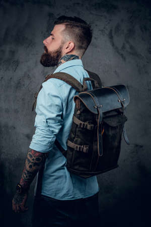 Bearded tattooed backpacker posing in studio.の写真素材