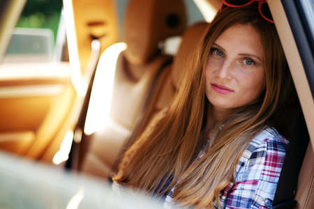 Portrait of freckled female in a car on back seat.の写真素材
