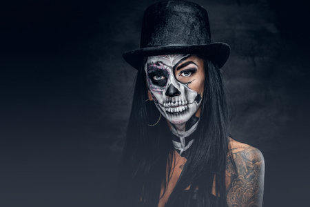 Portrait of female with skull make up in top hat on Halloween.の写真素材
