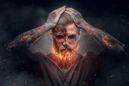 Demonic male with burning beard and arms in fire sparks.の写真素材