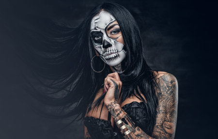 Day of the dead. Tattooed female with sugar skull make up.の写真素材