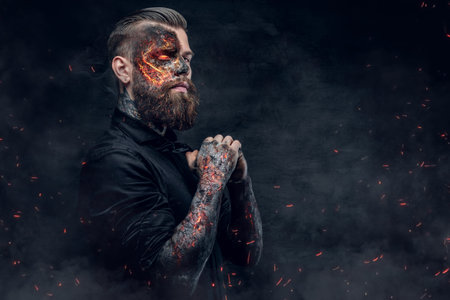 A demon man with a burning face in a fire sparks and smoke. Halloween 31 October.の写真素材