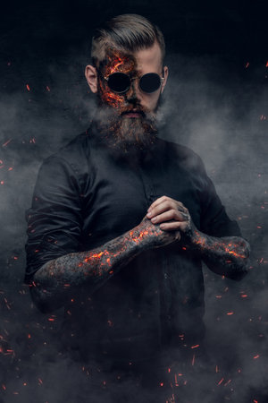 Creepy demonic male in a fire sparks and smoke.
