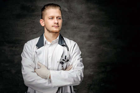 Portrait of confident young medical doctor on grey background.の写真素材