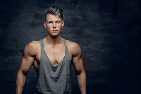 Portrait of an attractive sporty man in a t shirt isolated on grey background.の写真素材