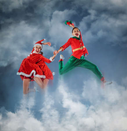 Funny kids in Peter pan and snow maiden costume flying in a sky.の写真素材