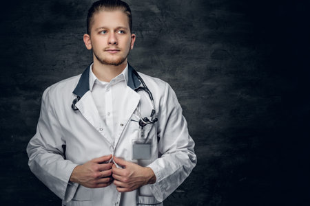Studio portrait of young medical doctor on grey background.