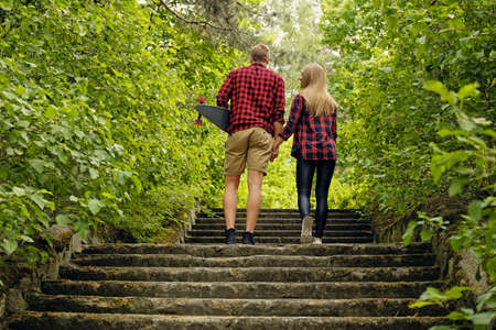 Skateboarders couple to go upstairs in nature parks.の写真素材