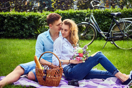 Loving couple at a picnic after bicycle ride in a park.の写真素材