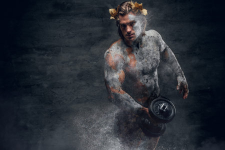 Crumbling statue - Ancient Greek male sportsmen holds dumbbell.の写真素材