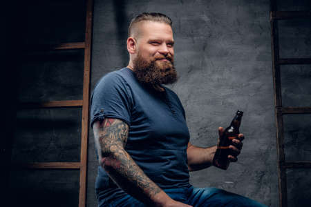 Bearded tattooed hipster male enjoys of a beer.の写真素材