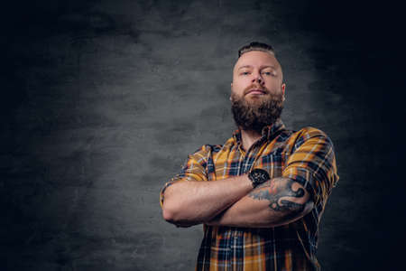 Brutal bearded male with crossed arms, dressed in a yellow plaid shirt.の写真素材