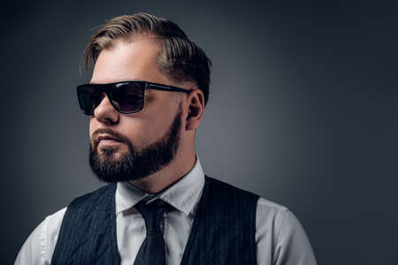 Bearded elegant male in sunglasses wearing waistcoat and bow tie.の写真素材