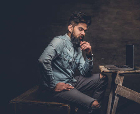 Stylish bearded Indian male working with laptop.の写真素材