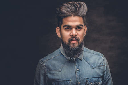 Portrait of stylish bearded Indian male dressed in a denim jacket.の写真素材