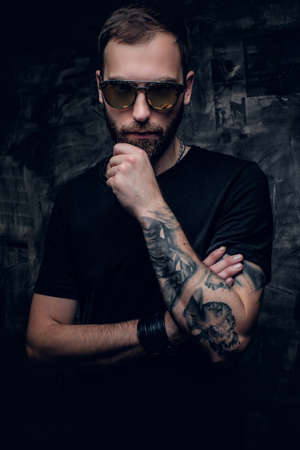 Bearded male in sunglasses with tattoo on his arm.の写真素材