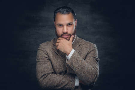 Portrait of bearded black man with crossed arms wearing a wool suit.の写真素材