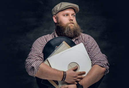 Fat bearded hipster man holds vinyl records.の写真素材