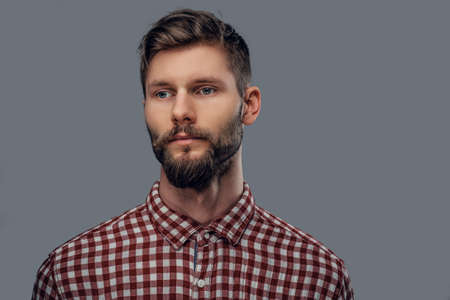 Portrait of a handsome bearded hipster man dressed in a fleece shirt isolated on grey background.の写真素材