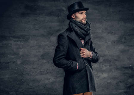 Portrait of an elegant bearded hipster man dressed stylish jacket and a cylinder hat.の写真素材