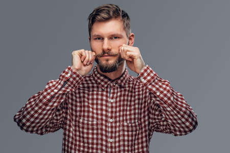 Portrait of a handsome bearded hipster man dressed in a fleece shirt isolated on grey background.の写真素材