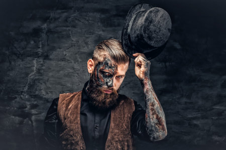 Portrait of a scary bearded male with burning make up and cylinder hat.の写真素材