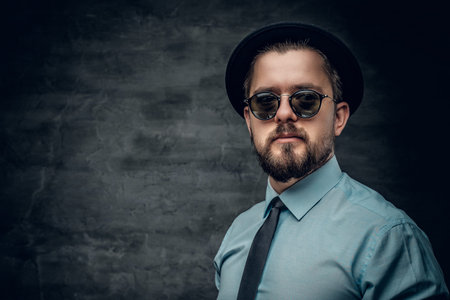 Portrait of bearded hipster dressed in a white shirt with bow tie and a hat.の写真素材