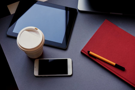 Open laptop, smart phone and tablet PC on a table.