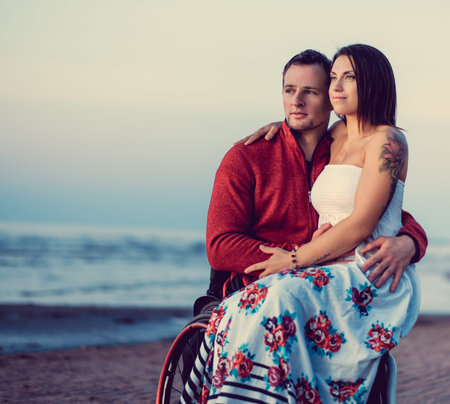 Handicapped young couple resting on a beach.