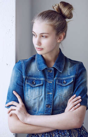 Portrait of a blue eyed blond female dressed in a denim jacket.の写真素材