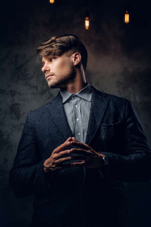 Portrait of stylish maledressed in a suit over grey background.の写真素材