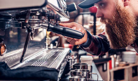 Bearded male is making coffee in a professional coffee machine.の写真素材
