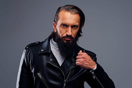 Portrait of bearded male with long hair dressed in a black leather jacket.の写真素材
