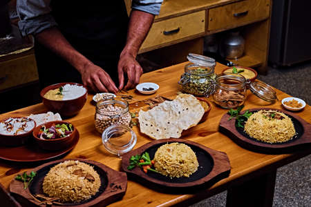 Indian male preparing Asian meals with rice in a kitchen.の写真素材