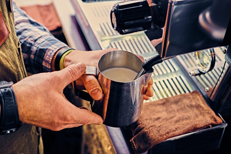 A man preparing cappuccino in a coffee shop.の写真素材