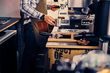 A man preparing cappuccino in a coffee shop.