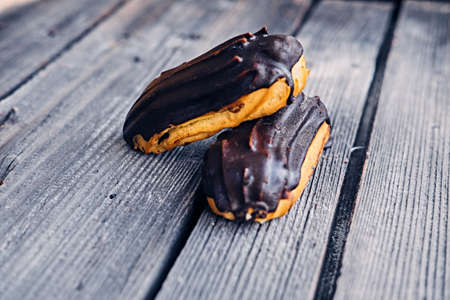 Delicious chocolate eclairs with berries on a grey wooden table.の写真素材