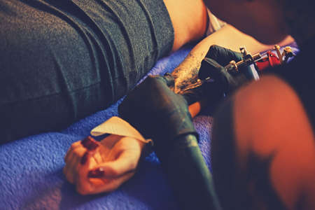 Close up image of making a tattoo on a woman's arm.の写真素材