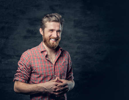 Studio portrait of positive blond bearded male dressed in a red fleece shirt makes conversation.の写真素材