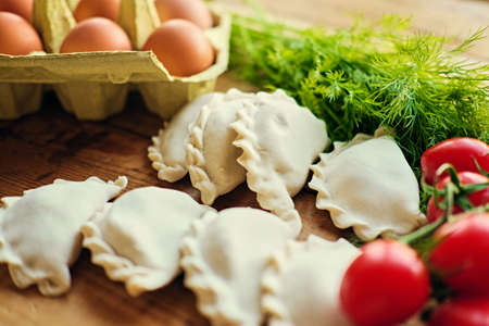 Frozen dumplings with cherry tomatoes, eggs and parsley.の写真素材