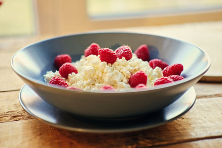Diet curd with raspberry on a plate.