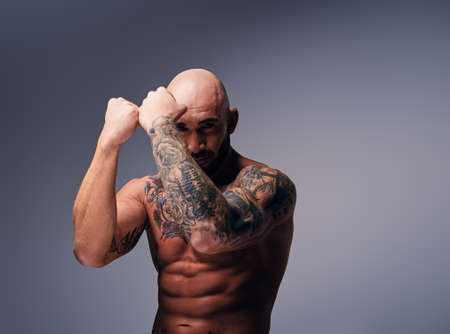 Brutal shaved head fighter with tattooed body.の写真素材