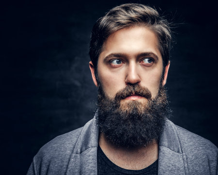 Studio portrait of full throttle bearded male over grey background.の写真素材