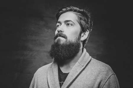 Studio portrait of full throttle bearded male over grey background.の写真素材