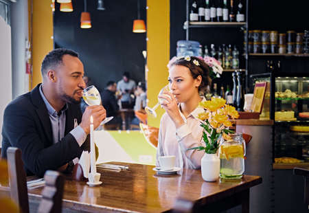 Loving black American couple on a date drinking wine in a restaurant.のeditorial素材