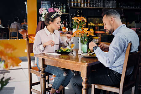 Black American male and female eating vegan food in a restaurant.のeditorial素材