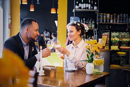 Loving black American couple on a date drinking wine in a restaurant.のeditorial素材